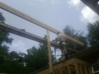Carpenter setting a ridge beam over a new addition frame — Ice Dam Removal by Roofing Brothers in Alhambra