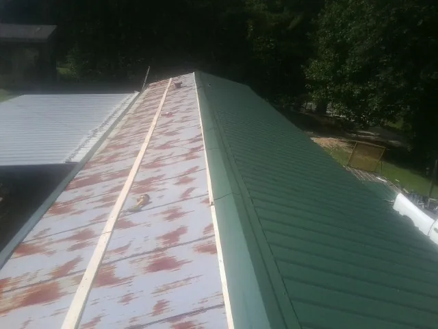 Old rusted panels beside newly installed green metal roofing — Wind Damage Roof Repair by Roofing Brothers in Alhambra